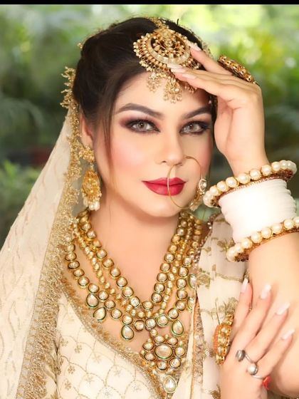 A bride in an ivory lehenga with a stunning layered gold and Kundan rani haar. The look is completed with a matching maang tikka and nath.