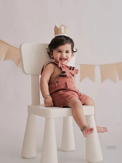 A happy one-year-old sitting like a king on his little throne. Our simple, modern props are perfect for creating clean and stylish first birthday portraits.