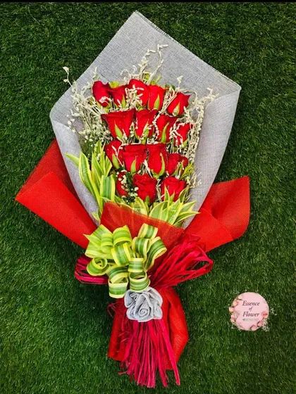 A simple yet beautiful bouquet of red roses wrapped in red and natural jute paper. The layered wrapping and unique bow add a touch of artistry.