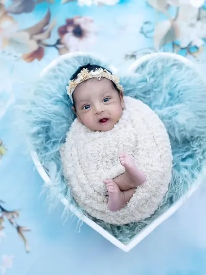 A beautiful one-month-old angel nestled in a heart-shaped bowl. The soft blue fur and floral background make this a truly lovely portrait.