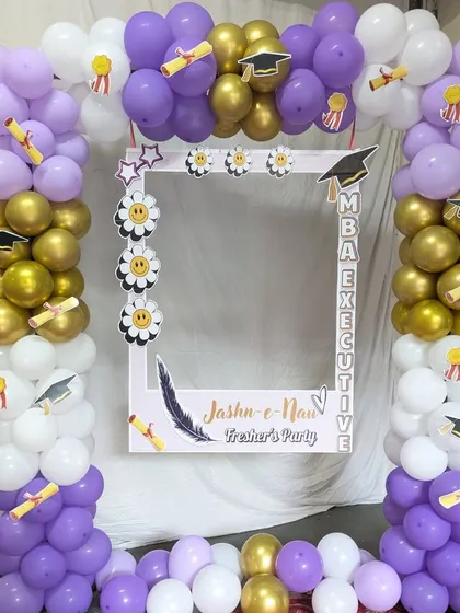 A custom photo booth frame designed for a college fresher's party. This interactive element, surrounded by a matching balloon arch, provides a dedicated spot for students to take memorable pictures.