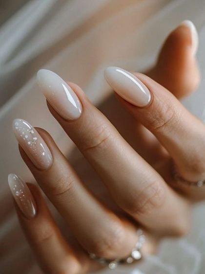 The perfect example of "less is more" for bridal nails. A clean, milky white color on a classic almond shape, with a subtle glitter accent nail.
