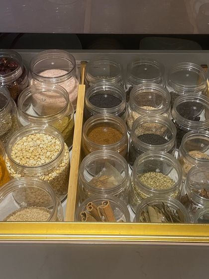 A close-up of a spice drawer where jars are organized with a bamboo divider. This simple tool helps keep everything in place, preventing jars from rolling around.