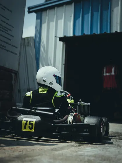 A driver waits in his kart in the pit lane.