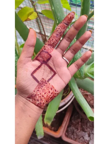 A modern, geometric design that creates a jewelry-like effect on the hand, connecting the finger to the palm.