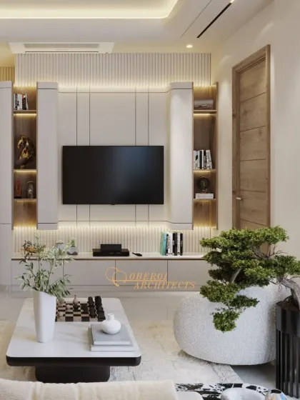 The television unit is designed to be both a functional and aesthetic feature. Integrated shelving with backlighting provides space for decor, while the fluted panels add textural interest to the wall.
