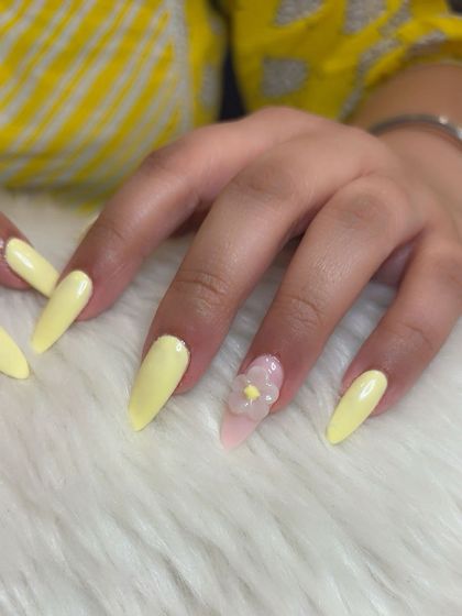 A whisper of sunshine on your nails. This set combines a cheerful pastel yellow with accent nails featuring delicate, translucent 3D flowers on a soft pink base.