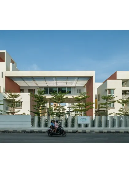 The entrance to Brigade Parkside East in Bengaluru. A triple-height colonnade acts as a transition from the busy street to the quiet interior, immediately introducing the central, cascading green terraces that form the core of the community.