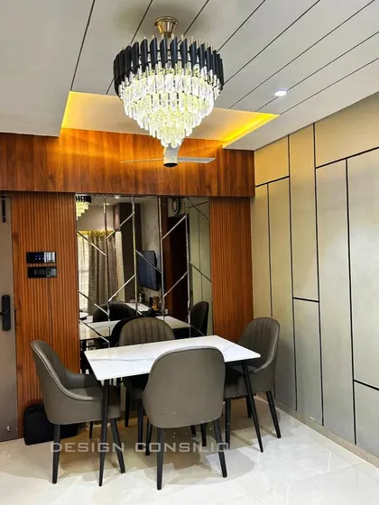 We designed this dining area to feel both grand and intimate. The crystal chandelier sets a luxurious tone, while the mirrored wall panel reflects light and creates an illusion of a larger space.