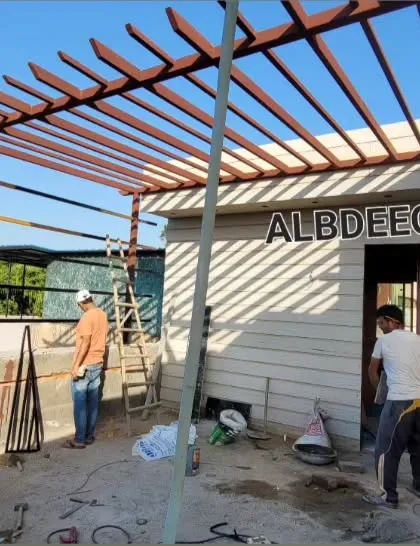 This work-in-progress shot from a site in Rohini shows a large pergola frame being installed next to a prefabricated room. You can see the basic structure before the final roofing and finishing touches are applied.