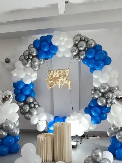 A blue, white, and silver balloon ring with a neon sign, perfect for a living room corner.