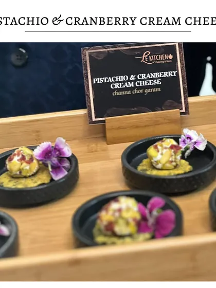 Our Pistachio and Cranberry Cream Cheese bites, served on a crispy cracker and garnished with an edible flower.