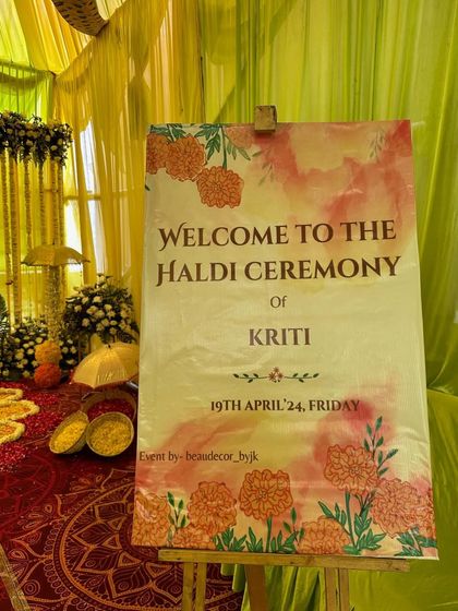 A personalized welcome sign for Kriti's Haldi ceremony, designed with a soft watercolor effect and marigold illustrations to match the decor.