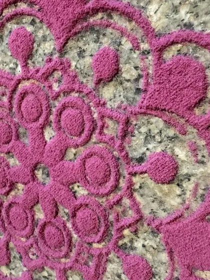 The rich texture of natural pink Rangoli powder. Unlike synthetic colors, these powders are soft and have an earthy feel, connecting us more deeply to the art form.