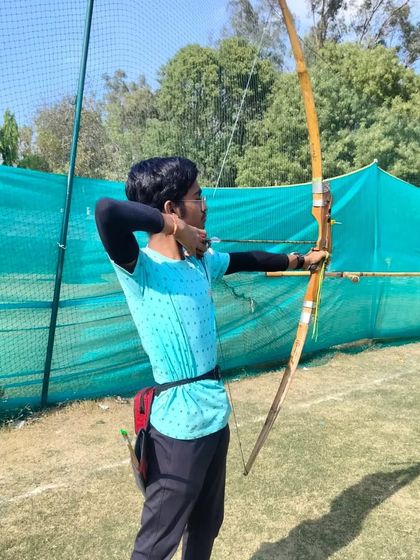 An archer takes aim at our training facility, demonstrating the focus and proper form taught by our expert coaches.