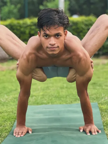 A powerful arm balance that requires open hips and strong shoulders. The direct gaze shows the intense focus required.