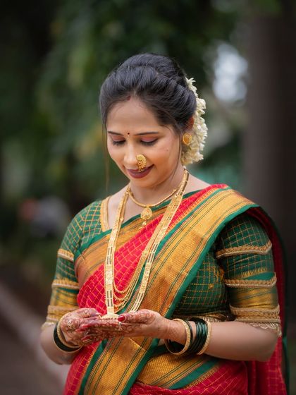 A close-up portrait focusing on the woman's traditional jewellery and serene expression during her Vat Purnima observance.