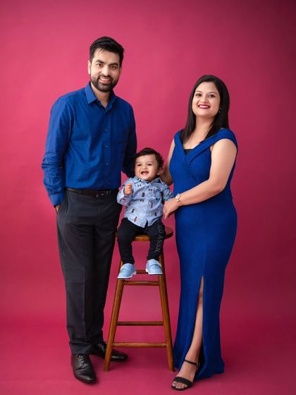A vibrant family portrait against a bold pink background. This shows how we can use color to create a modern, stylish, and fun family photo.