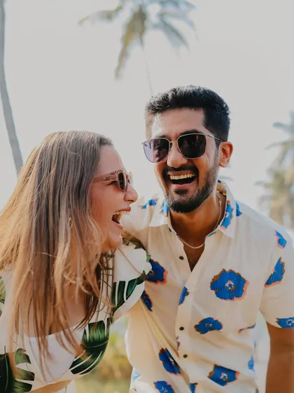 The kind of laughter that's infectious. This close-up from a Goa pre-wedding shoot captures a moment of pure, uninhibited joy between the couple, with a beautiful, sunny backdrop.