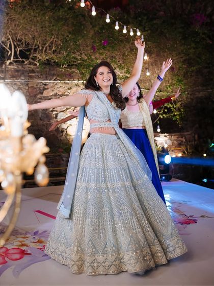 The bride dancing with her arms outstretched, fully embracing the joy of her sangeet night.