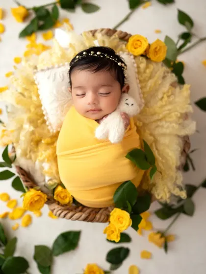 A slightly different angle of this yellow rose setup, showing the baby girl holding a tiny white teddy bear. It's these small details that add so much sweetness.