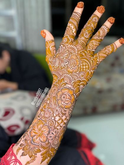The beautiful orange-brown color of a fresh henna stain on the back of the hand.