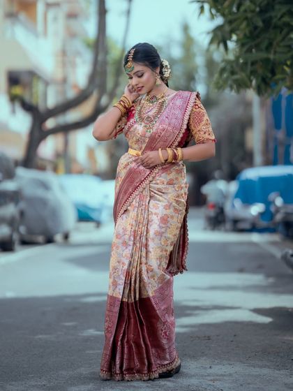 A candid moment showing the intricate work on the silk saree and the matching temple jewellery set.