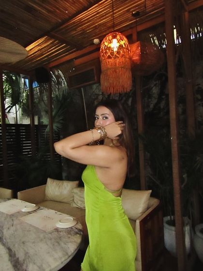A playful pose in the green backless dress, showing off its fun and flirty vibe.