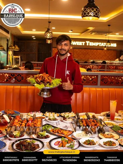 Delight on every plate. A happy guest gives a thumbs up, surrounded by our lavish buffet, showcasing the joy we bring to your table.