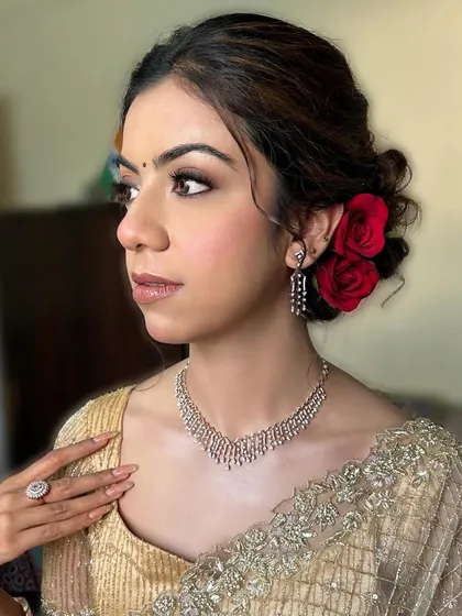 A stunning reception look. This client wanted a classic, elegant look, and we delivered with a soft smokey eye, a nude lip, and a beautiful bun adorned with red roses. ❤️