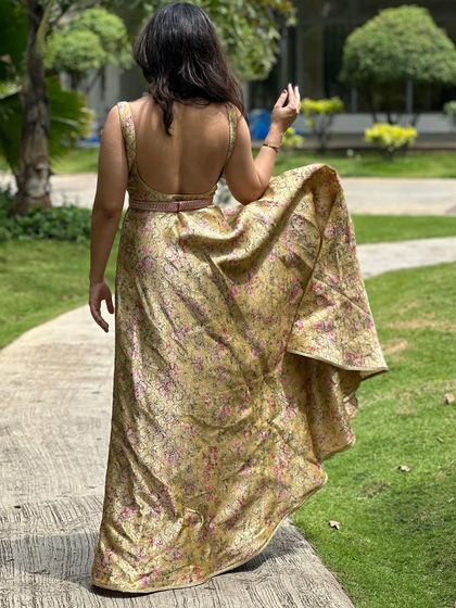 The back view of the floral brocade gown, showcasing the low back design and the beautiful flow of the fabric.