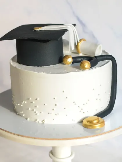 A classic convocation cake to celebrate a medical school graduation. The simple white cake is decorated with a handmade fondant graduation cap, stethoscope, and diploma.