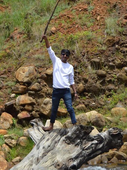 A fun, triumphant pose on a log by the river. Every trip is an adventure.
