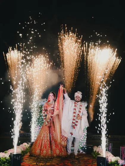 A grand exit or entrance. The couple walks down the aisle as cold pyro fireworks light up their path, creating a spectacular moment.