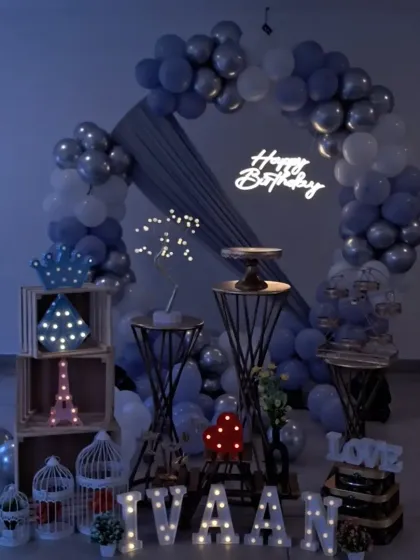 The birthday setup for Ivaan, shown in low light to emphasize the glow from the neon sign and marquee letters.