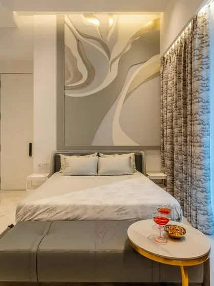A closer view of the bed and the custom headboard, showcasing the subtle textures and colors. The small, gold-accented side table adds a touch of glamour to the minimalist design.