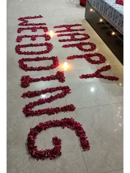 For a personal touch, I can write messages on the floor using fresh rose petals. Here, "Happy Wedding" is written out and lit with small candles.