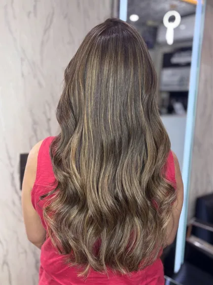 The back view of the Beige Biscoff color, styled with beautiful waves. This shade is a great example of a modern, neutral blonde that is very on trend.