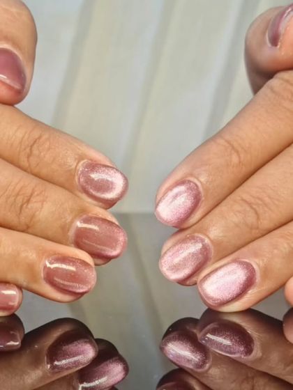 A soft and elegant pink cat-eye effect on short, natural nails, offering a subtle yet beautiful shimmer.