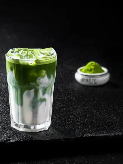 A simple yet elegant iced matcha latte, showing the swirl of green matcha into white milk.