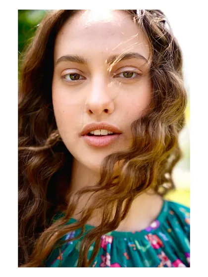A beautiful, sun-kissed close-up of a model. The natural lighting and soft focus create a warm, relatable portrait that complements the collection's aesthetic.