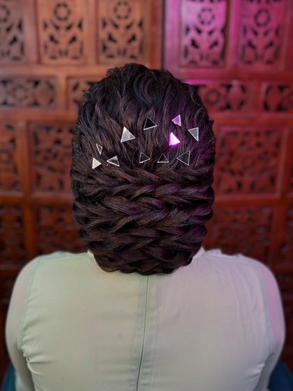 A modern and chic textured bun. This hairstyle is decorated with trendy triangular mirror accessories, giving it a very contemporary feel.