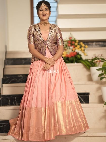 My beautiful client looks so charming in this custom housewarming outfit. I paired a flowing peach Kanchi-border skirt with a chic brocade jacket, blending traditional fabric with a modern, layered silhouette.