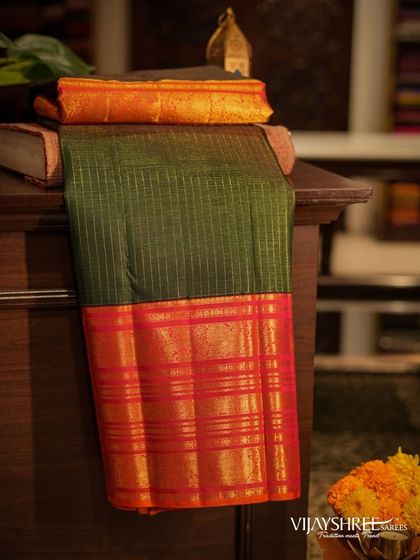 A red and green Kanjivaram with a traditional Korvai gap border, showcasing the sharp contrast between the body and the border.