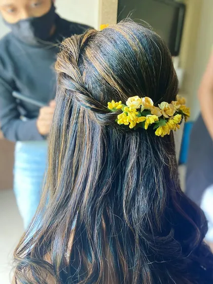 A beautiful Haldi hairstyle from the back. I created a simple twist and adorned it with a line of fresh yellow flowers to match the theme.