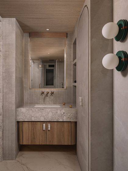 Inside the father's bathroom, a monolith vanity and wood-finished ceilings continue the bedroom's calm allure. The material palette of stone and wood creates a warm, tactile experience.