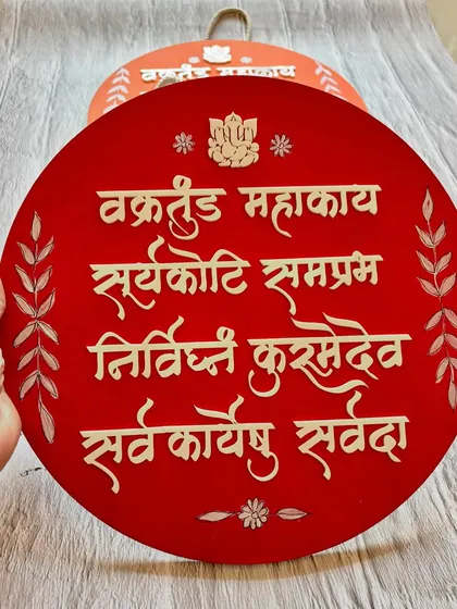A close-up of the intricate, hand-painted details on the 'Vakratunda Mahakaya' wall hanging.
