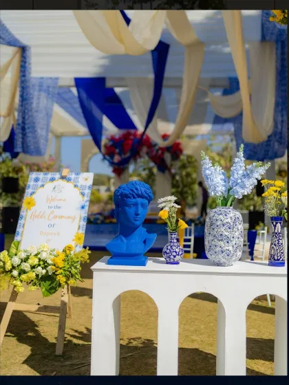 The decor featured unique elements like a blue David bust and patterned vases, blending classic art with a vibrant, tropical wedding theme.