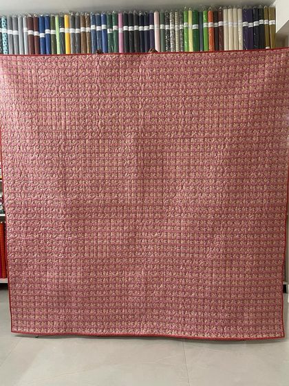 The back of the quilt, revealing the detailed quilting work across the entire surface.