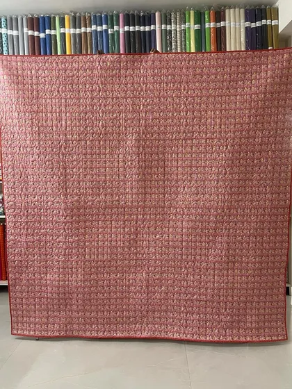 The back of the quilt, revealing the detailed quilting work across the entire surface.